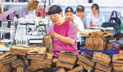 阜平縣顧家臺(tái)村九歌皮具有限公司,村民在加工箱包。當(dāng)?shù)厣a(chǎn)的箱包通過線上線下俏銷全國各地。